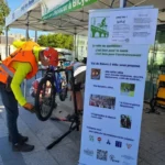 Membres de Mieux se Déplacer à Bicyclette réparants un vélo enfant lors d'un atelier réparation de vélo sur le parvis de la ligne 14 du métro à L'Haÿ-les-Roses